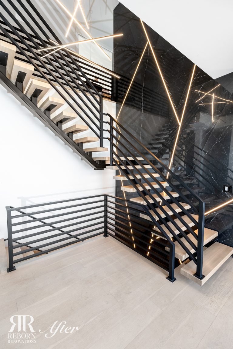 A modern staircase with black railings and lighting.