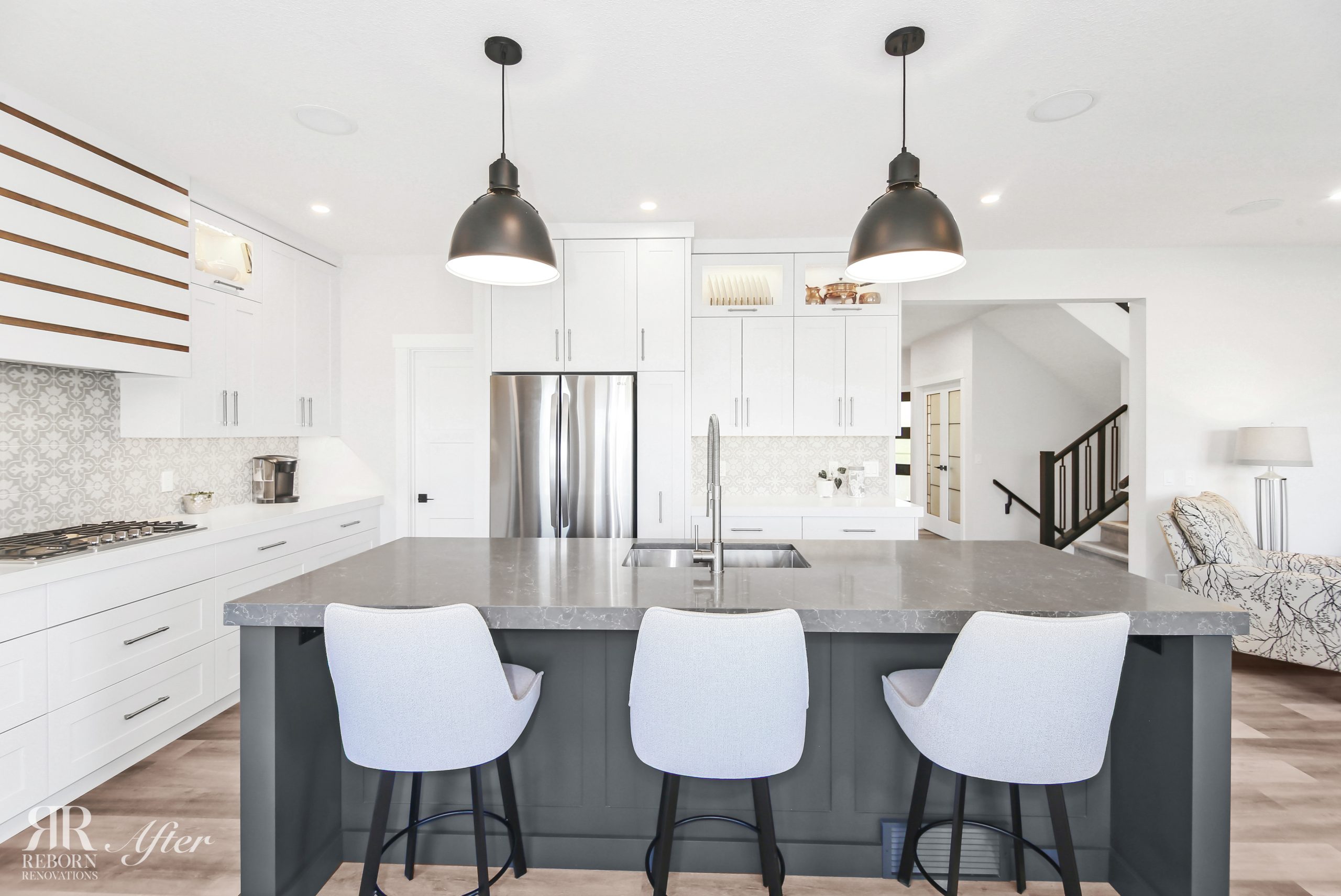 A complete home and kitchen remodel featuring a white kitchen with a grey island and stools in Hanson Ranch.
