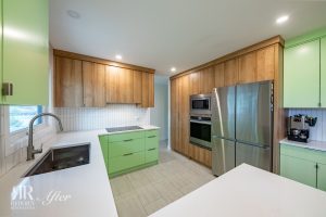 A kitchen with green cabinets and stainless steel appliances.