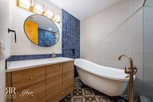 A bathroom with a bathtub, sink and mirror.
