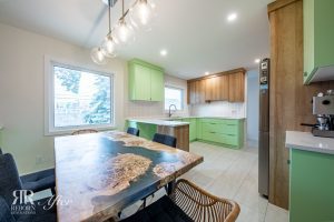 A kitchen with green cabinets and a table.