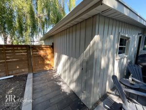 A small backyard with a patio and chairs undergoing an Exterior Remodel in Wildwood.